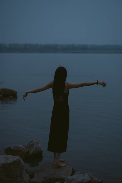 young woman in black dress on the beach - Φωτογραφία, εικόνα