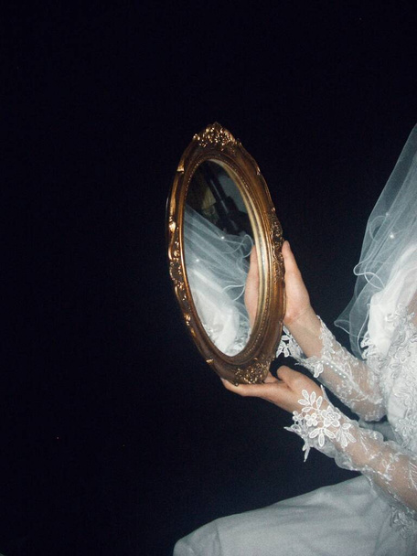 bride in a white dress with a veil on a black background - Fotó, kép