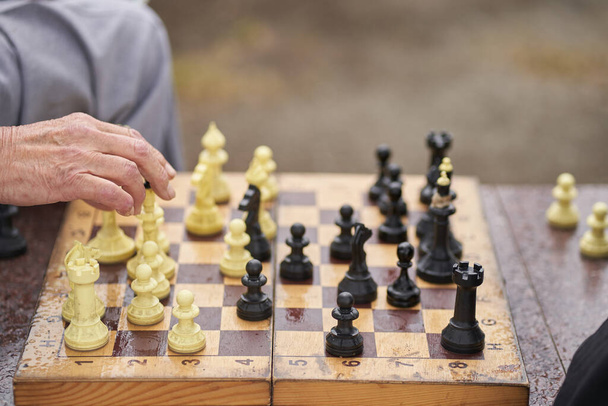 Δύο άντρες παίζουν σκάκι. Σκάκι επιτραπέζιο παιχνίδι έννοια των επιχειρηματικών ιδεών και του ανταγωνισμού και στρατηγικό σχέδιο η έννοια της επιτυχίας - Φωτογραφία, εικόνα