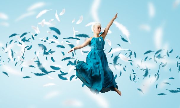Жінка в блакитній сукні стрибає
 - Фото, зображення