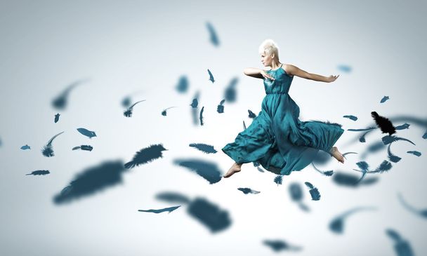 ジャンプ青いドレスの女 - 写真・画像