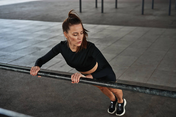 Young fit woman in black sportswear doing push ups  - Foto, Bild