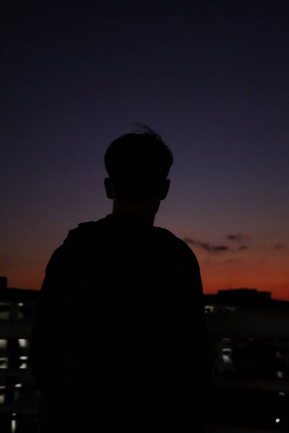 silhouette of a man in a suit on a background of a sunset - 写真・画像