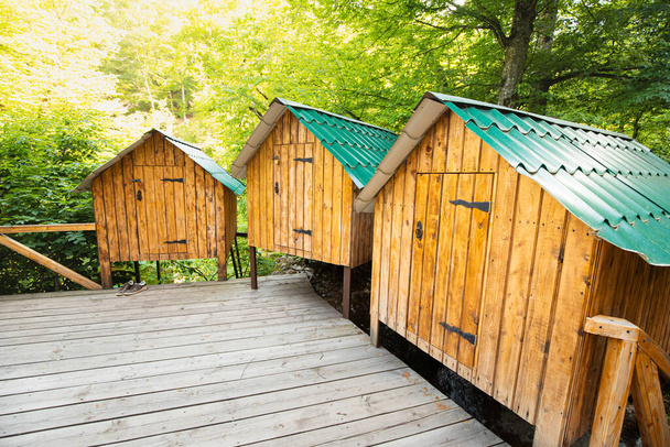 Kicsi és hangulatos faházak és kunyhók kempingeznek az erdőben az ösvényen. Éjszaka a természetben és szabadban - Fotó, kép