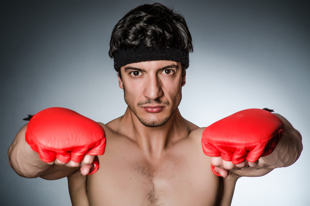 Muskelkräftiger Boxer mit roten Handschuhen - Foto, Bild