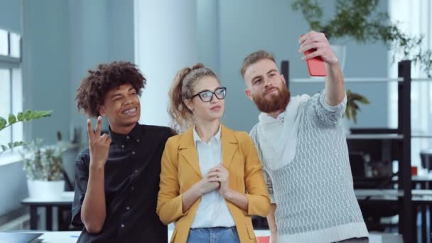 Colleagues taking funny selfie in office - Materiał filmowy, wideo