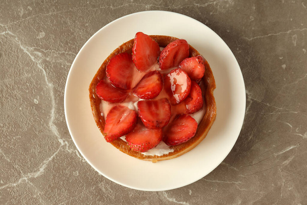 Plate with strawberry tart on gray textured table. - Fotoğraf, Görsel
