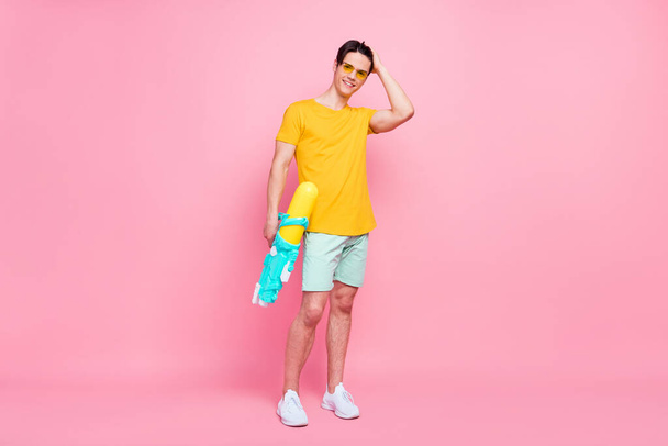 Full length photo of young guy happy positive smile hold water gun splash summer vacation isolated over pastel color background - Zdjęcie, obraz