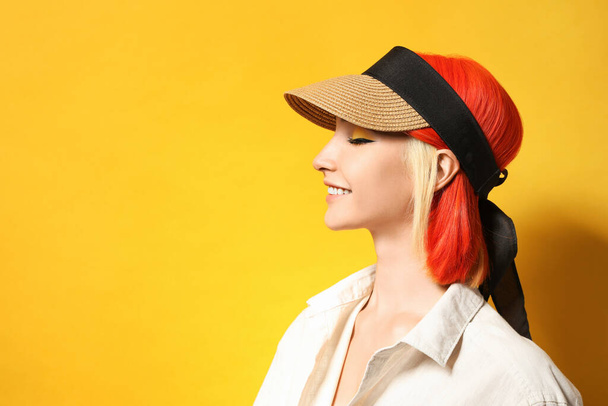 Beautiful young woman with bright dyed hair on orange background, space for text - Foto, imagen