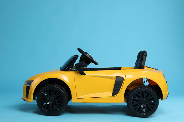 Child's electric toy car on light blue background - Фото, изображение