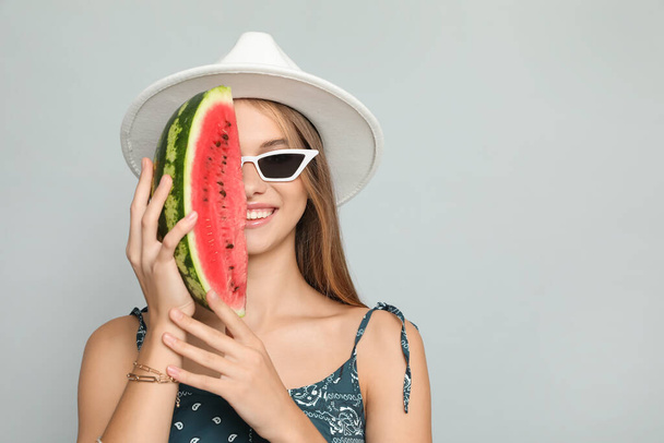 Beautiful girl with watermelon on grey background. Space for text - Foto, Imagem