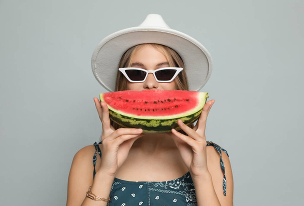 Beautiful girl with watermelon on grey background - Photo, Image