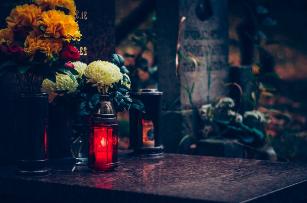 candela accesa in lanterna durante il Giorno di Tutti i Santi su tomba su cimitero - Foto, immagini