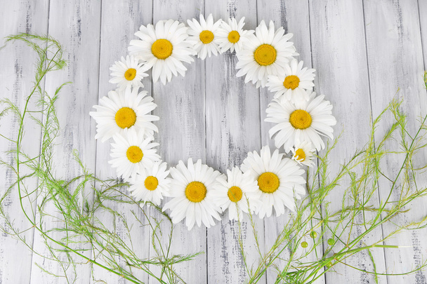 Chamomile wreath on wooden background - Foto, afbeelding