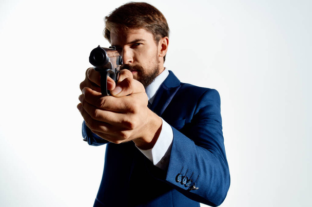 Geschäftsmann Geheimagent mit einer Waffe in der Hand auf isoliertem Hintergrund. Hochwertiges Foto - Foto, Bild
