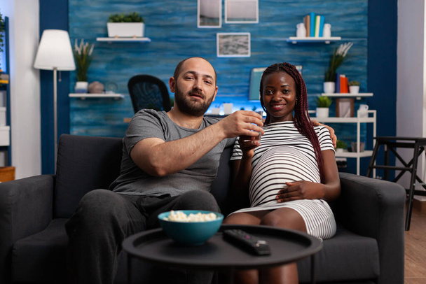 POV διαφυλετικό ζευγάρι με εγκυμοσύνη βλέποντας ταινία - Φωτογραφία, εικόνα