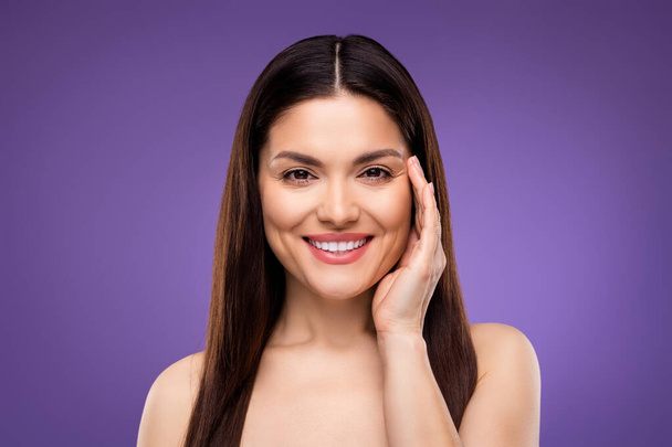 Portrait of attractive cheerful woman touching flawless skin laser peeling effect isolated over bright violet purple color background - Zdjęcie, obraz