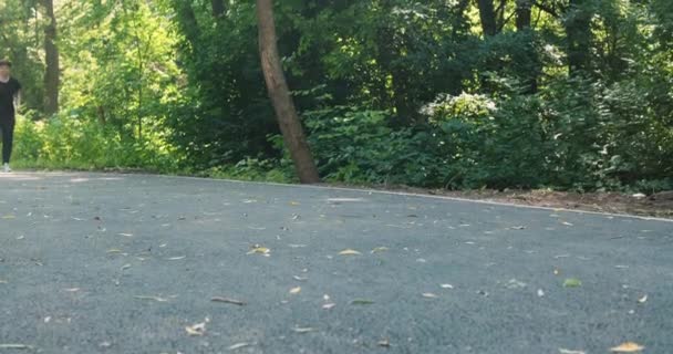 Młoda pulchna kobieta zajmuje się lekkoatletyką na świeżym powietrzu. Dziewczyna z dodatkowymi kilogramami biegnie do parku, aby schudnąć - Materiał filmowy, wideo