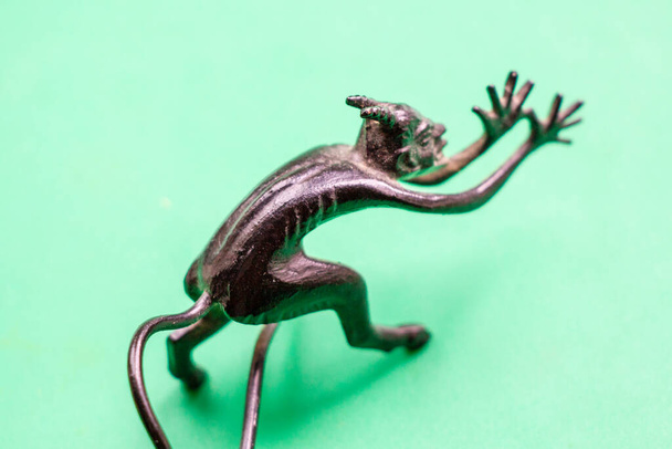 Une petite sculpture en métal du diable avec une queue montrant sa langue - Photo, image