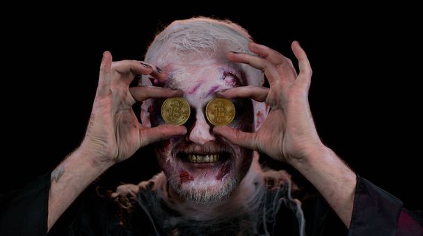 Zombie hombre con maquillaje con heridas falsas cicatrices que muestran bitcoins de oro, minería criptomoneda btc - Foto, imagen