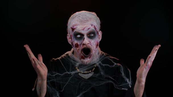 Pelottava mies Halloween zombie nostaa kätensä yllättäen etsivät järkyttynyt äkillinen voitto, Vau - Valokuva, kuva