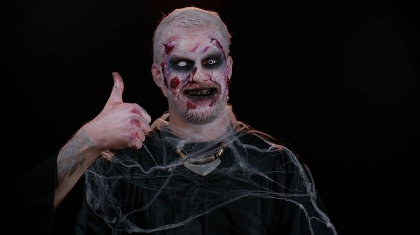 Hombre siniestro Halloween zombie plantea pulgares hacia arriba está de acuerdo con algo o da respuesta positiva, le gusta - Foto, Imagen