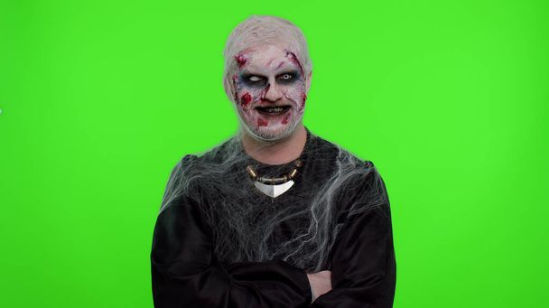 Веселий моторошний чоловік Хеллоуїн зомбі робить обличчя, дивиться на камеру, жахливо посміхається брудними зубами
 - Фото, зображення