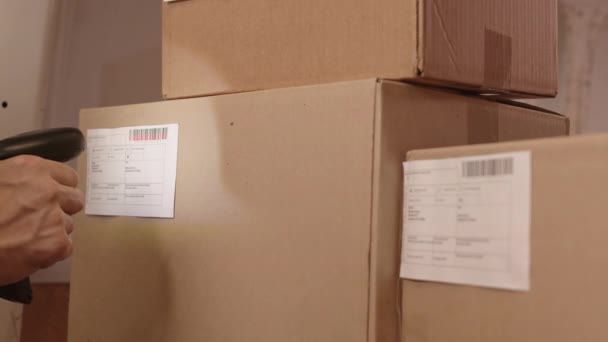 Opgesloten close-up van bijgesneden persoon met de hand alleen in frame scannen barcodes op kartonnen dozen - Video