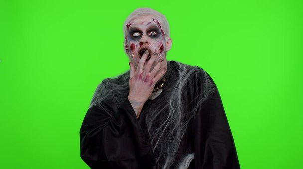 Przerażający człowiek Halloween zombie podnoszące ręce w zaskoczeniu wyglądając zszokowany nagłym zwycięstwem - Zdjęcie, obraz