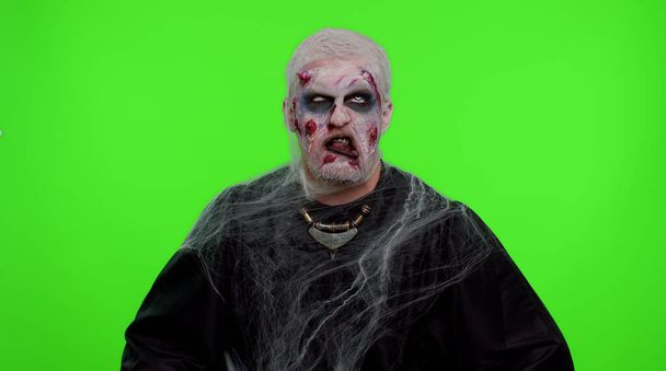 Hombre siniestro asustadizo zombie de Halloween haciendo juguetonas expresiones faciales tontas haciendo muecas tonterías - Foto, imagen