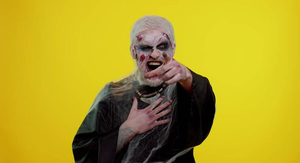 Хеллоуїн зомбі чоловік вказує палець на камеру, сміється голосно, приборкаючи робить смішний смішний жарт
 - Фото, зображення