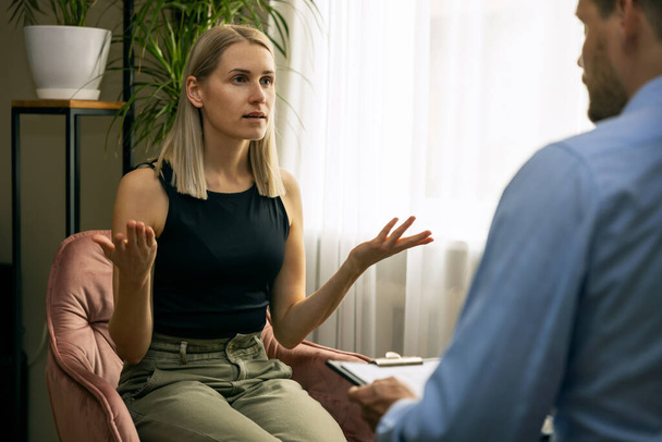 psicoterapia - psicoterapeuta masculino o psiquiatra que lleva a cabo el asesoramiento con la mujer joven. trastorno de salud mental - Foto, Imagen