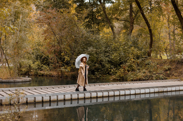 een vrouw in trendy herfstkleding in het stadspark in de herfst. weekend. najaarstrends. vrije plaats voor tekst - Foto, afbeelding