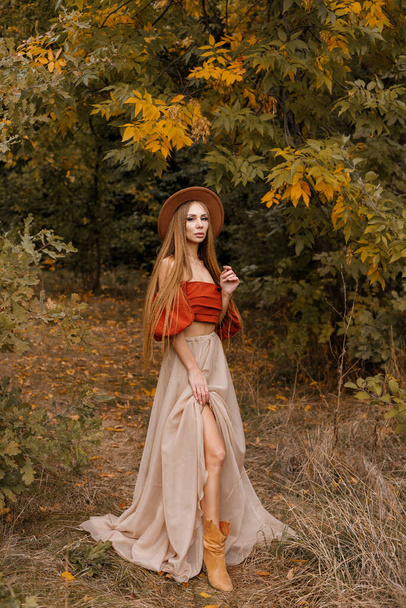 a beautiful woman in a brown hat in autumn clothes in the autumn forest. autumn mood. blog - Photo, Image