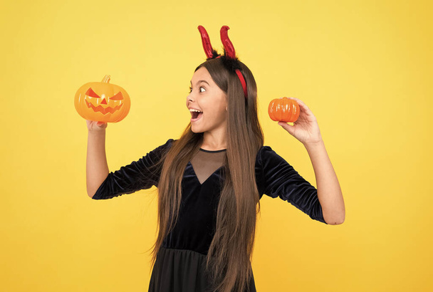 I only spook. happy halloween. child in imp horns with jack o lantern. kid wear devil horns hold pumpkin. childhood autumn holiday. funny teen girl ready to celebrate party. costume party fun - Foto, Bild