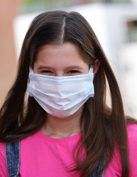 beautiful girl with long black hair and mask to protect herself from coronavirus - Photo, Image