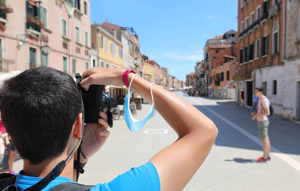 niño tomando fotos en la ciudad de Venecia con muy pocas personas durante el encierro - Foto, imagen