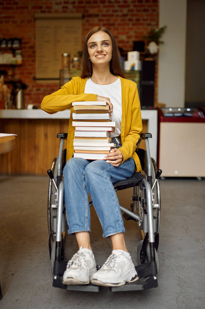 Behinderte Studentin hält Bücherstapel in der Hand - Foto, Bild