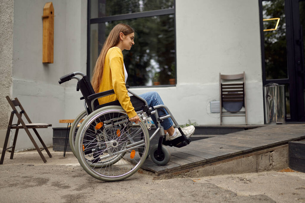 カフェのランプで車椅子の障害学生 - 写真・画像