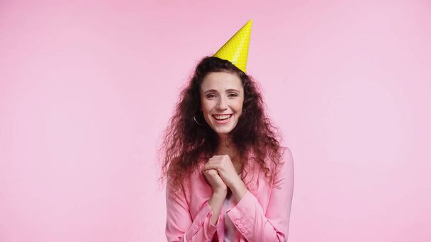 smiling young woman in party cap during birthday isolated on pink  - Zdjęcie, obraz