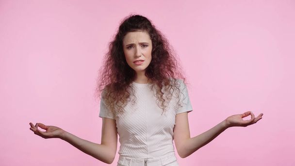 displeased woman showing shrug gesture isolated on pink - Foto, Imagem