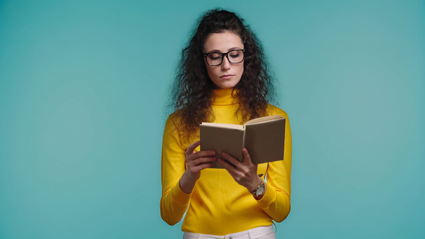 focused woman reading book isolated on blue  - Фото, зображення