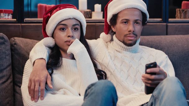 Africain américain regarder film avec petite amie dans santa chapeau - Photo, image