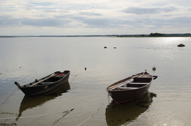 Due vecchie barche a remi in legno lungo la costa
 - Foto, immagini