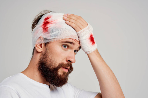 Sakallı, kafası bandajlı ve arka planı açık sakallı bir adam. Yüksek kalite fotoğraf - Fotoğraf, Görsel