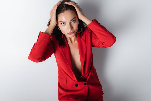 top view of trendy woman in red suit posing on grey - 写真・画像