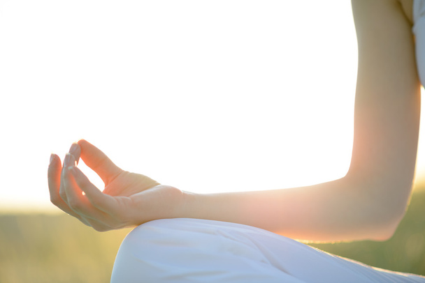 fiatal gyönyörű nő gyakorlatok jóga a napsütötte réten - Fotó, kép