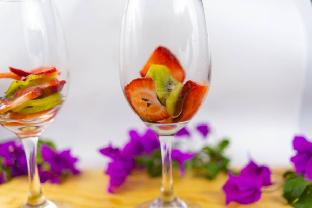 Erdbeer- und Kiwi-Scheiben in Weingläsern mit weißem Hintergrund - Foto, Bild