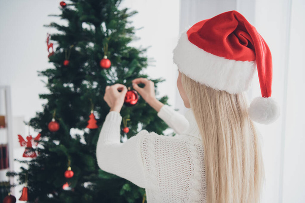 Fotografie mladé okouzlující žena závěsné Vánoce zdobit strom míč nosit Santa Claus klobouk uvnitř domu domů - Fotografie, Obrázek