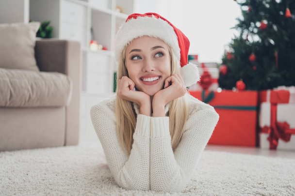 Photo of dreamy happy cheerful young woman lie carpet look enjoy christmas season smile indoors inside house home - Foto, afbeelding